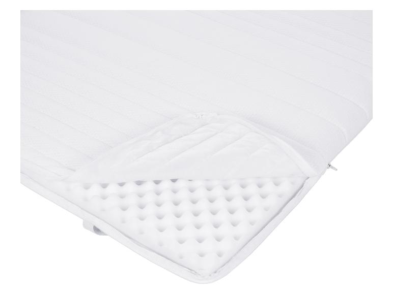 Matelas blanc avec fermeture éclair, montrant l'intérieur en mousse.