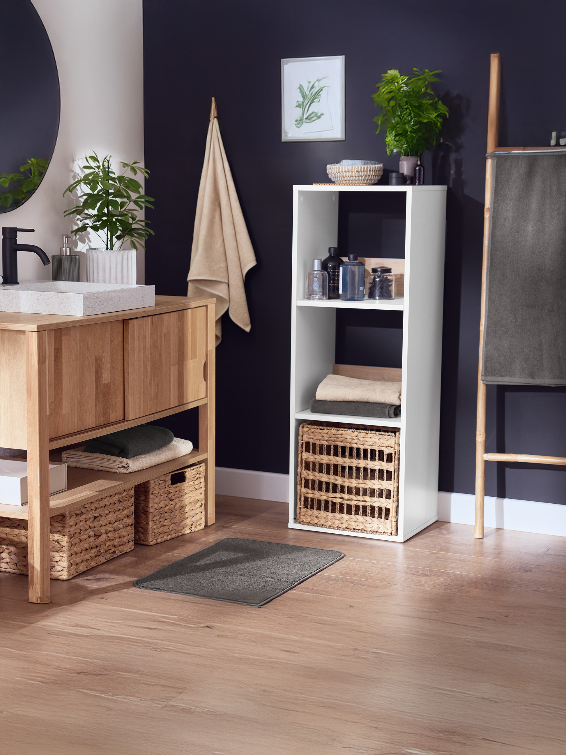 Salle de bain avec meuble-lavabo en bois, miroir, étagère de rangement blanche et porte-serviettes.