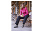 Femme portant un pull rose, un pantalon noir et des chaussures de randonnée.