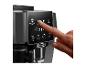 Doigt appuyant sur le bouton Espresso du panneau de commande d'une machine à café De'Longhi.