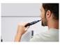 Un homme utilise une brosse à dents électrique.