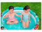 Deux fillettes jouent dans une piscine gonflable aux motifs de princesses Disney.