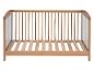 Un lit bébé en bois avec des barreaux.