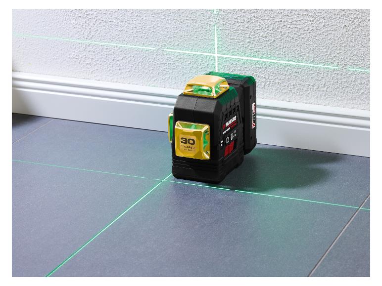 Niveau laser vert projetant des lignes horizontales et verticales dans une pièce.