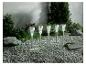 Cinq lampes solaires de jardin argentées sur du gravier