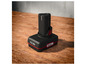 Une batterie noire X-Team de 4,0 Ah sur une table en bois.