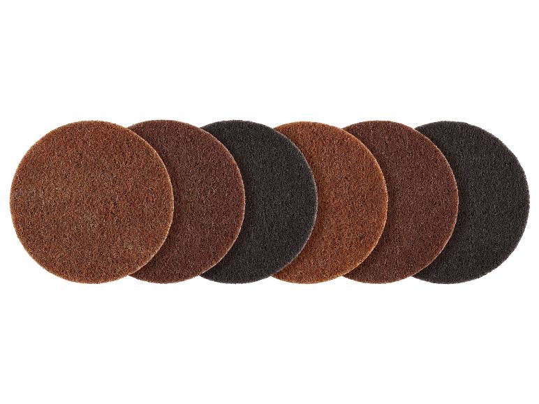 Sept disques abrasifs ronds dans des tons variés de marron et noir, alignés.