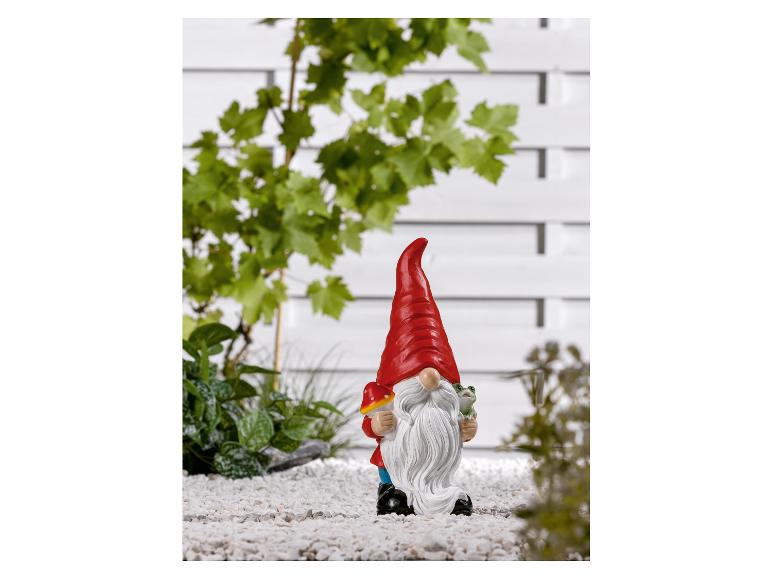 Un nain de jardin rouge avec un champignon et une grenouille.