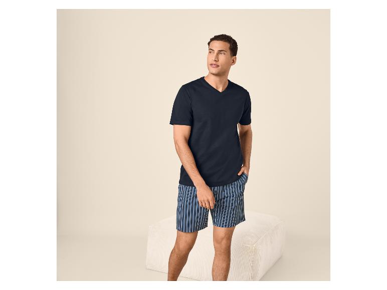 Homme en t-shirt col en V bleu marine et short de pyjama rayé bleu.