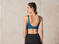 Une femme portant un soutien-gorge de sport bleu et un legging noir.
