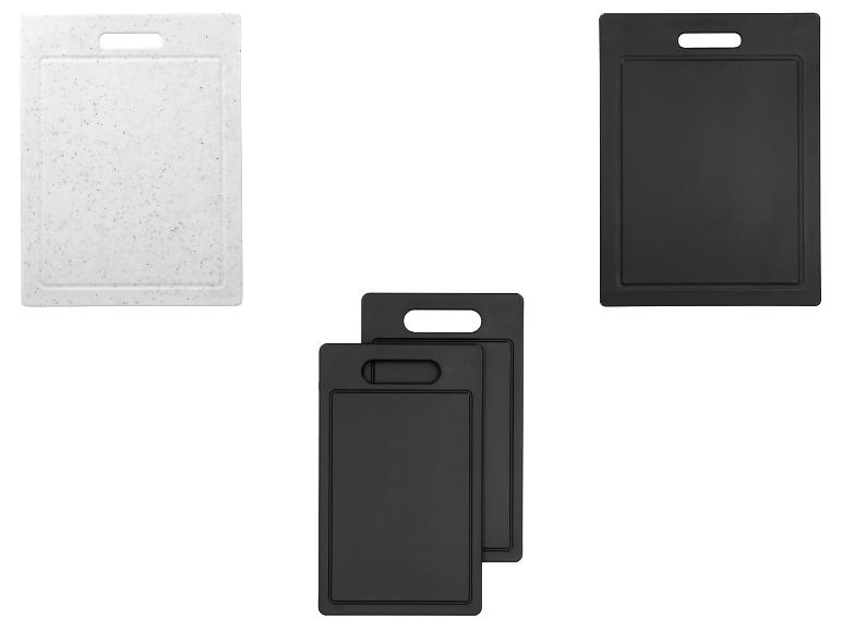 Ensemble de trois planches à découper noires et une blanche.