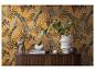 Meuble en bois avec vases, livres et buste devant un papier peint à motif jungle.