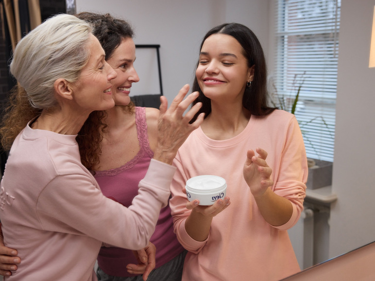 Trois femmes en rose regardant un pot de crème Cien.