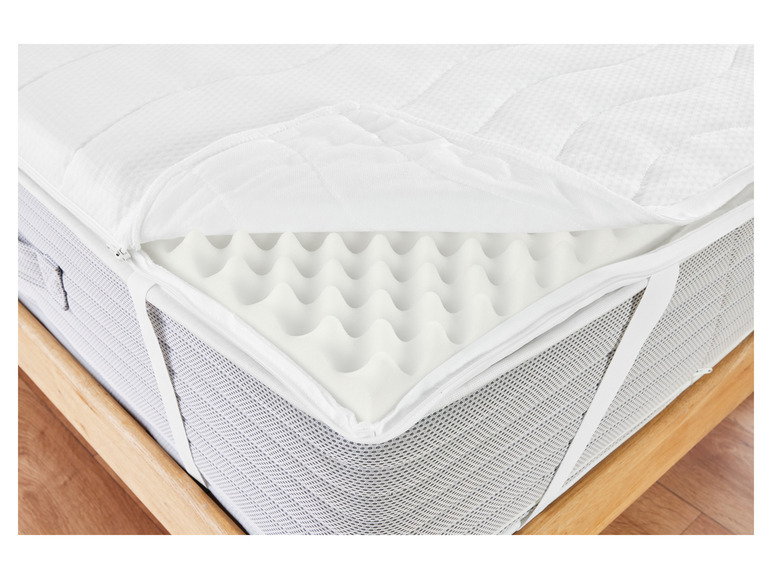 Un matelas blanc avec un surmatelas en mousse
