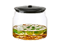 Bocal en verre pour conserves avec couvercle hermétique, rempli d'herbes et d'huile.
