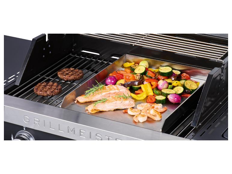 Barbecue à gaz avec burgers, saumon, crevettes et légumes sur une plancha.