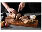 Une planche à découper en bois avec du pain, du fromage et des figues.