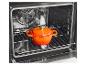 Cocotte en fonte orange à l'intérieur d'un four moderne sur une grille métallique.