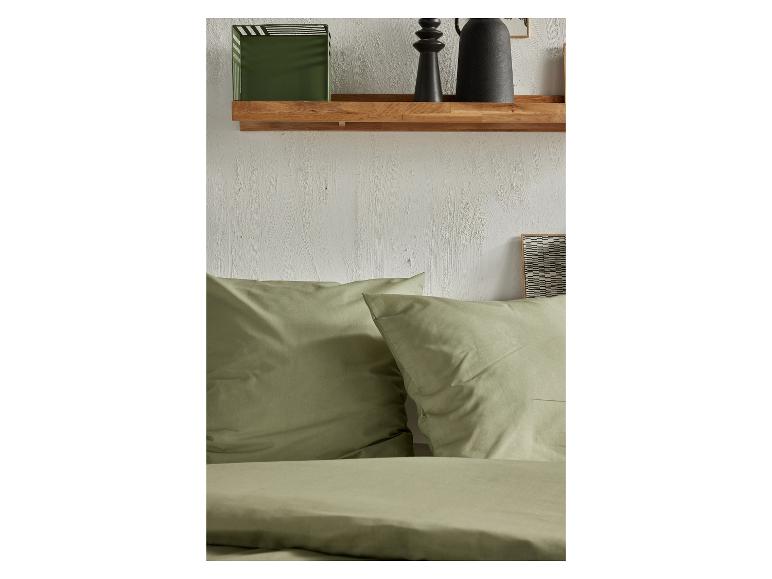 Une parure de lit verte avec des oreillers.