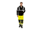 Un homme porte une veste noire Parkside et un pantalon jaune haute visibilité.