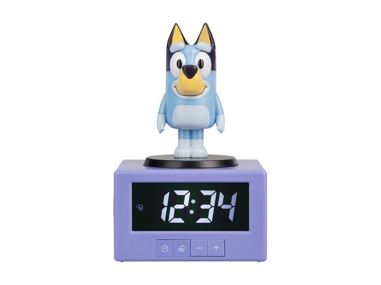 Réveil avec personnage de chien bleu et affichage numérique indiquant 12:34.