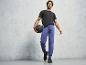 Un homme en t-shirt noir et pantalon de survêtement bleu tient un ballon de médecine.