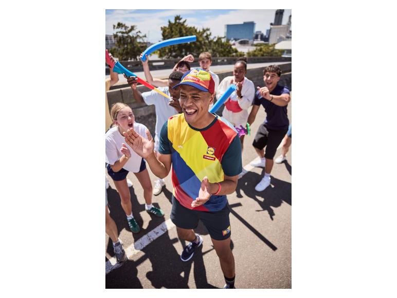 Jeunes en tenue de sport et casquettes, célébrant en extérieur.