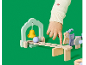 Main d'enfant jouant avec un jouet en bois cloche et piste à billes sur fond vert.