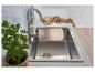 Évier de cuisine en acier inoxydable avec robinet chromé, torchon à motifs et plante en pot.