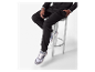 Un homme portant un pantalon de jogging noir et des baskets.