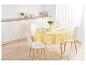 Une table ronde à manger avec une nappe jaune, des chaises blanches et des couverts.
