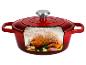 Cocotte rouge avec un poulet rôti, de l'ail et des herbes à l'intérieur.