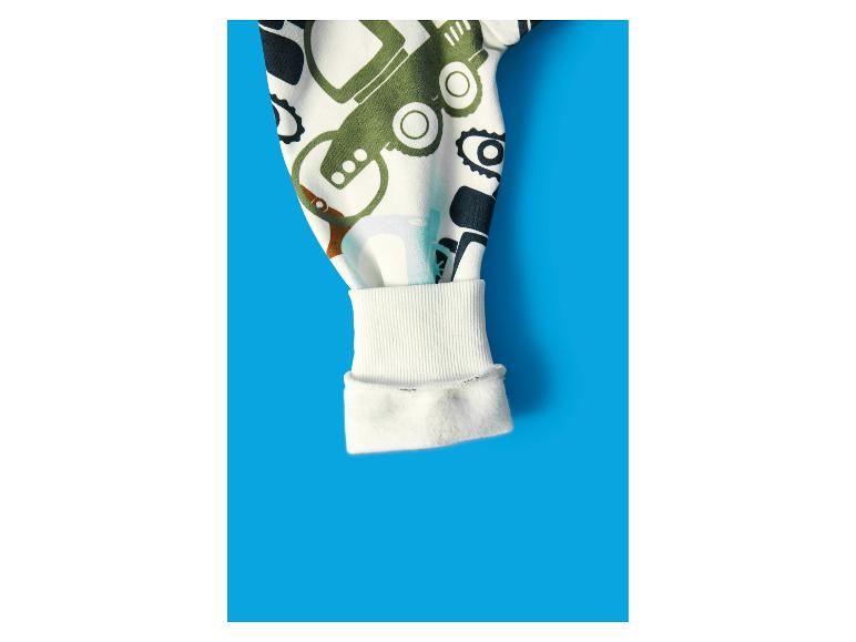 Manche de blouse enfant avec imprimé véhicules sur fond bleu.