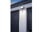 Projecteur LED extérieur avec détecteur de mouvement monté au-dessus du garage.