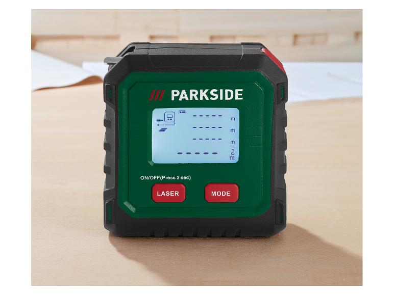 Télémètre laser avec affichage numérique et boutons rouges sur une surface en bois.
