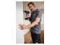 Un homme utilise une perceuse-visseuse Parkside pour fixer un panneau.
