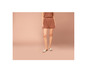 Une femme porte un short marron et des sandales blanches.