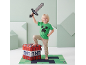 Enfant souriant avec épée jouet, t-shirt thème jeu vidéo et pouf de rangement TNT.