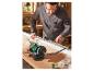 Un homme utilise une meuleuse Parkside pour aiguiser des outils dans son atelier de menuiserie.