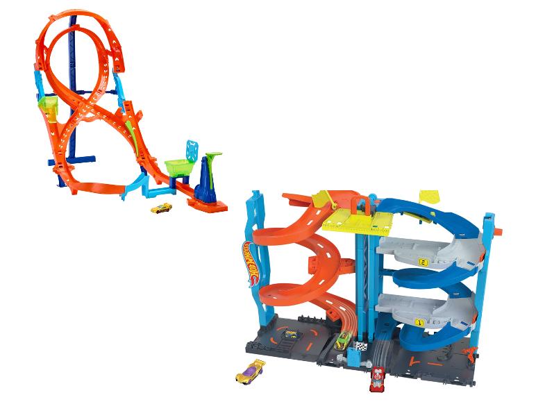 Deux ensembles de pistes Hot Wheels avec des voitures, l'un avec une grande boucle et l'autre avec un garage à plusieurs niveaux.
