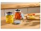 Deux bocaux en verre de citrons et carottes fermentés sur un comptoir en bois.