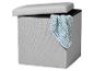 Boîte de rangement gris clair avec couvercle ouvert et couverture tricotée bleue.