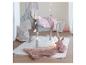 Cheval en bois gris avec couverture rose, tapis en fausse fourrure rose et lapin en peluche dans une chambre d'enfant.