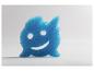 Éponge de nettoyage bleue en forme de monstre souriant.