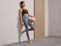 Une femme en tenue de sport tenant un ballon de fitness rose.