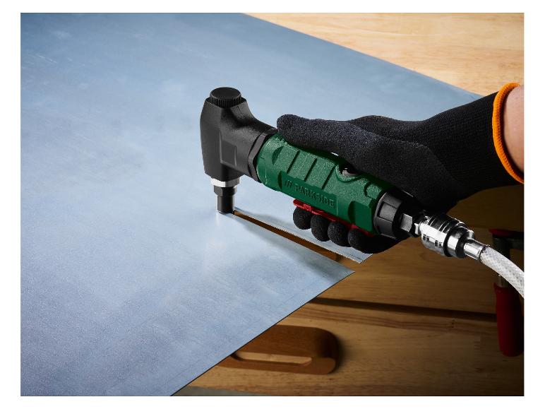 Outil de découpe Parkside coupant une tôle sur un établi en bois.