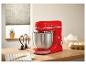 Robot pâtissier rouge avec bol et fouets sur un comptoir en bois.