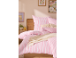 Parure de lit rayée rose et blanche avec coussins décoratifs et jeté de lit sur un lit en bois.