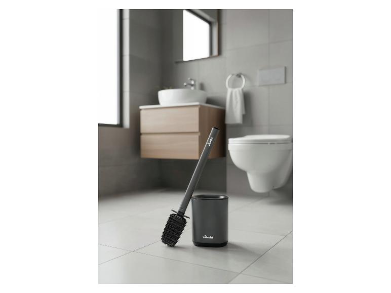 Brosse de toilette grise avec support dans une salle de bain moderne.