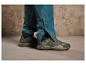 Deux paires de chaussures de randonnée vertes et une paire de jambes de pantalon imperméables bleues.